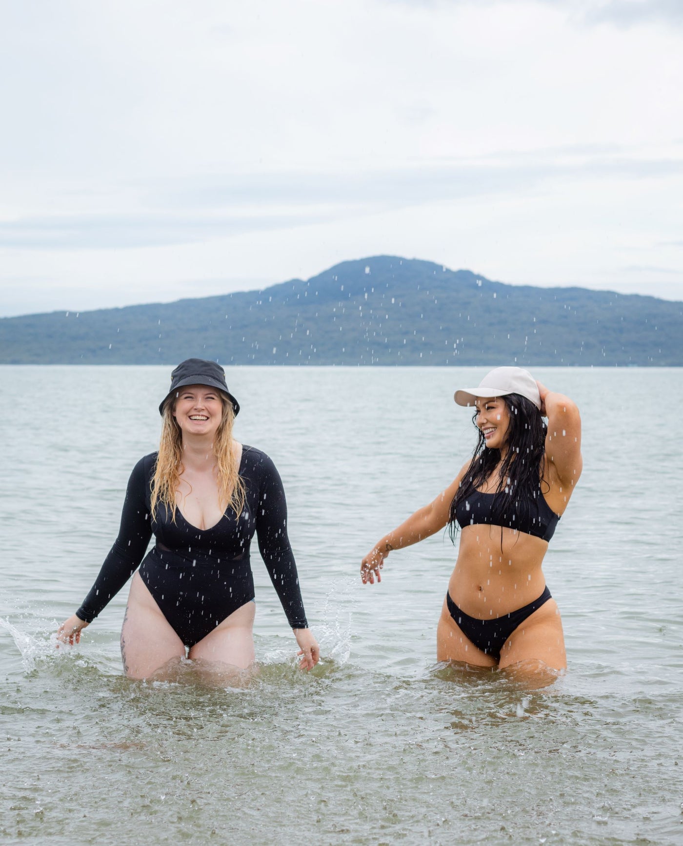 SWMR The Dip paddle suit at the beach with another model in a SWMR black bikini